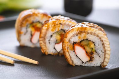 Pilavlı suşi, yengeç, salatalık, avokado, tobiko, yılan balığı. Suşi menüsü. Japon yemeği..