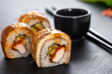 Pilavlı suşi, yengeç, salatalık, avokado, tobiko, yılan balığı. Suşi menüsü. Japon yemeği..