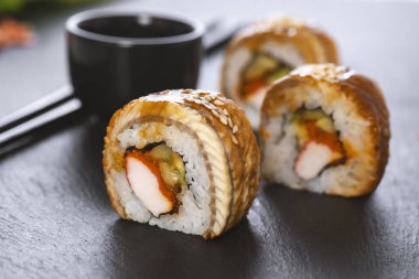 Pilavlı suşi, yengeç, salatalık, avokado, tobiko, yılan balığı. Suşi menüsü. Japon yemeği..