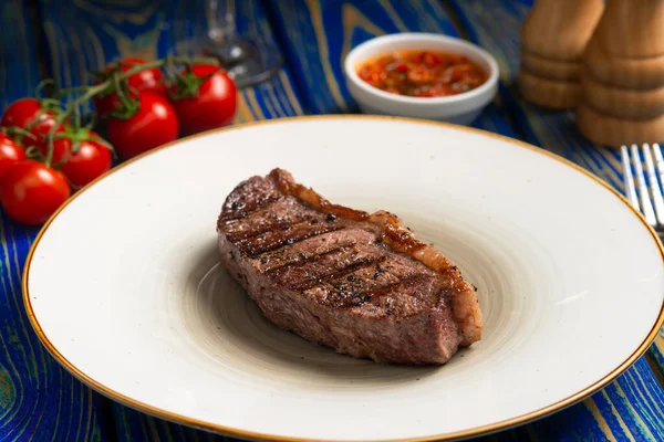 Gebratenes Steak Kirschtomaten Salz Und Pfeffer Auf Blauem Holztisch — Stockfoto