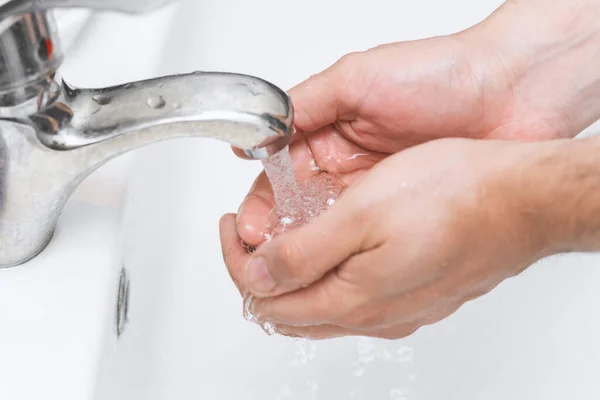 man washes his hands in the bathroom.The best protection against corona virus infection.Corona Virus pandemic protection by cleaning hands frequently.