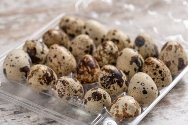 Tahta bir masada plastik kaplarda bıldırcın yumurtaları.