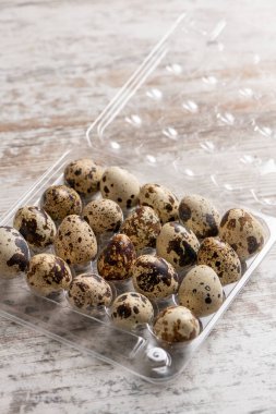 Tahta bir masada plastik kaplarda bıldırcın yumurtaları.