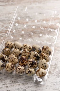 Tahta bir masada plastik kaplarda bıldırcın yumurtaları.