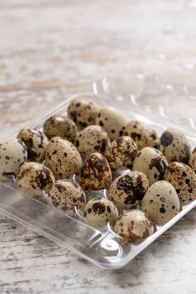 Tahta bir masada plastik kaplarda bıldırcın yumurtaları.