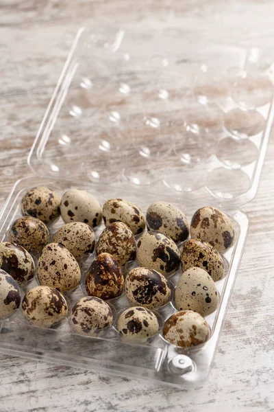 Tahta bir masada plastik kaplarda bıldırcın yumurtaları.