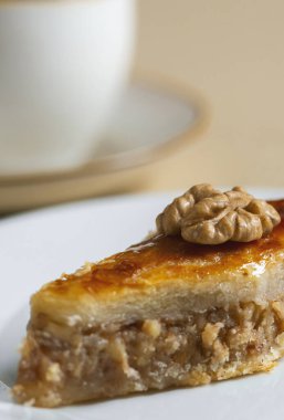 Geleneksel Arap tatlı baklavası ve bir fincan kahve ya da çayla birlikte beyaz tabakta ceviz. Ev yapımı fındıklı ve ballı baklava..