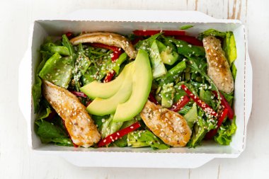 Paketinde avokado olan tavuk salatası. Sağlıklı öğle yemeği