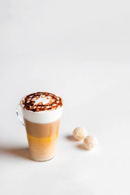 Sütlü kahve ya da sütlü macchiato bardağı, beyaz arka planda. Sütlü ve katmanlı İtalyan kahvesi. Gurme kahve..