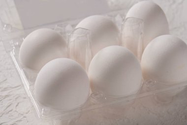 Open box with six whole white eggs  on white background with clipping path. Fresh organic chicken eggs in plastic pack or egg container