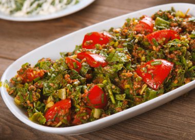 Oryantal tabbouleh salatası ahşap bir masada.
