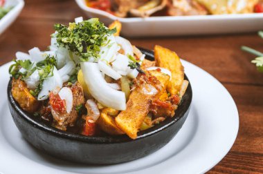 Beef stew with potatoes, carrots and herbs on black background with copy