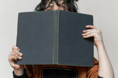 Bir çocuk onun elinde bir kitapla