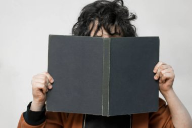 Bir çocuk onun elinde bir kitapla