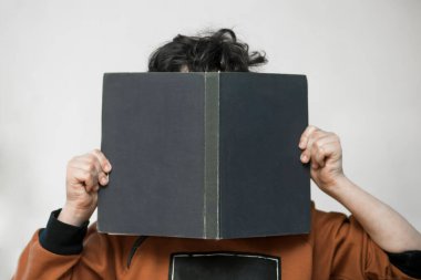 Bir çocuk onun elinde bir kitapla