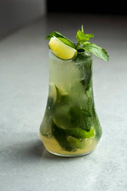 Mojito kireç ve highball cam gri taş zemin üzerine nane kokteyli .