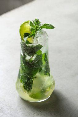 Mojito kireç ve highball cam gri taş zemin üzerine nane kokteyli .