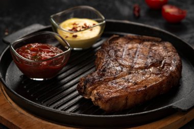 pork steak with vegetables in a black iron pan