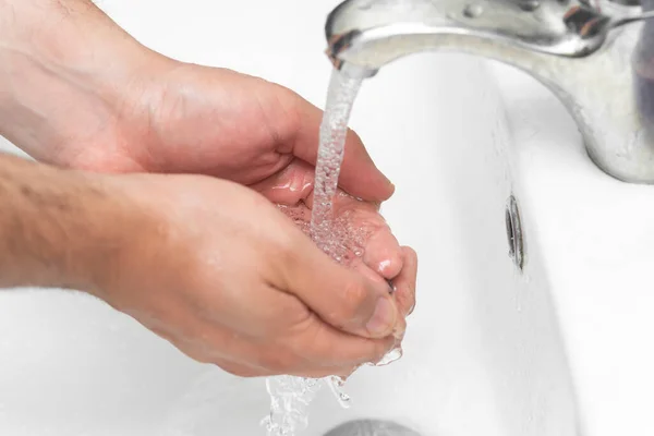 man washes his hands in the bathroom.The best protection against corona virus infection.Corona Virus pandemic protection by cleaning hands frequently.