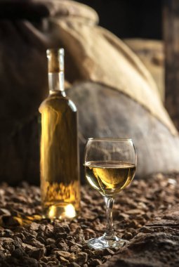 Şarap mahzeninde beyaz şarap kadehi olan şarap şişesi.