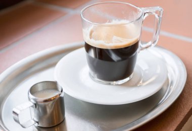 Duble espresso bir cam ve kafede bir tablo üzerinde süt