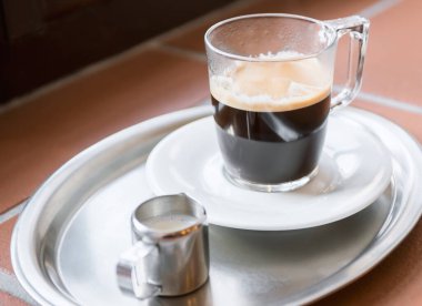 Duble espresso bir cam ve kafede bir tablo üzerinde süt