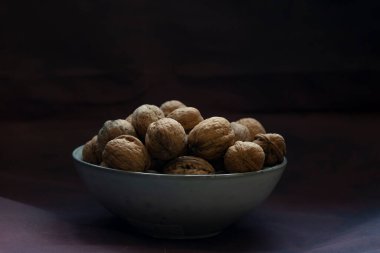 Fotokopi alanı ile siyah zemin üzerinde ceviz dolu bir kase