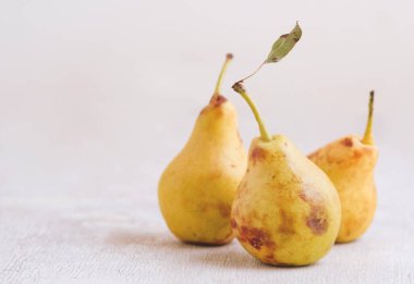 Beyaz masada servis edilen olgun sarı armutlar, sağlıklı yiyecekler.