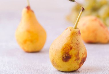 Beyaz masada servis edilen olgun sarı armutlar, sağlıklı yiyecekler.