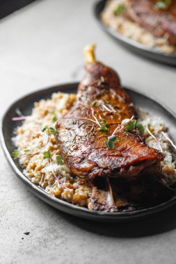 Ördek bacağı, fırında sebze ve parmesan peyniri ile servis edilir.