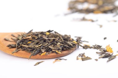 beyaz arka plan üzerinde izole ahşap bir kaşık üzerinde aromatik yeşil kuru çay,