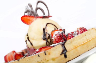 Dondurma, çilek ve çikolatayla servis edilen waffle 'ın yakın görüntüsü