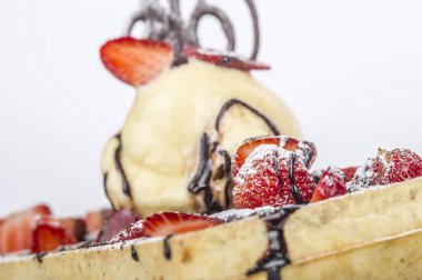 Dondurma, çilek ve çikolatayla servis edilen waffle 'ın yakın görüntüsü