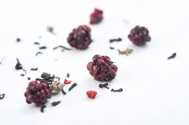 beyaz arka plan üzerinde izole ahşap bir kaşık üzerinde ahududu ile aromatik siyah kuru çay