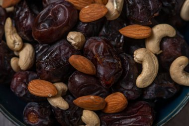 Siyah kasede servis edilen çiğ kaju fıstığı ve incir.