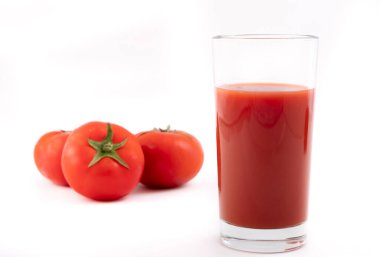 Bir bardak domates suyu ve beyaz bir arka plan üzerinde olgun domates