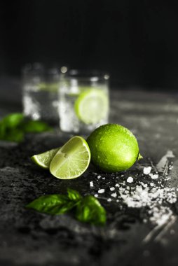 Ön planda kireç meyvesi ve arka planda kuyruk kuyruğu olan bardaklar.