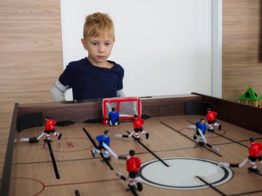 masa hokeyi. eğlence için dinamik sosyal oyun. Avrupalı çocuk oyuna tutkulu..