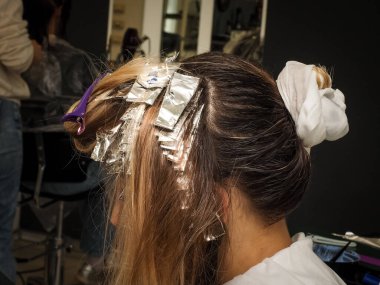 Kadın saçı boyama aşamasında. Güzellik ve saç bakımı endüstrisi, saç kesimi, boyama, aydınlatma, tonlama, restorasyon.