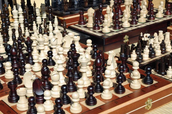 Šachové figurky na dřevěné desce, černé a bílé — Stock fotografie