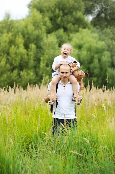 Happy father carrying daughter on his neck — Stock Photo, Image