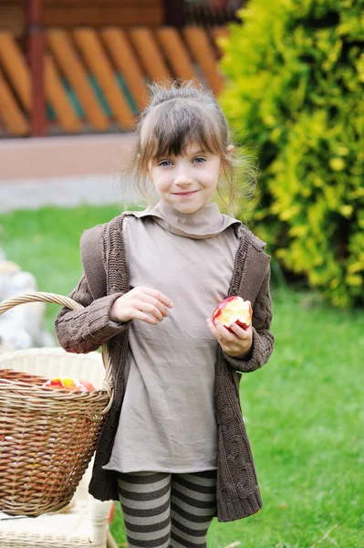 Malá dívka pózuje venku s košíkem — Stock fotografie