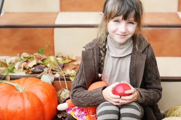 Portrait of little girl with apple and pumpkin — Stock Photo, Image