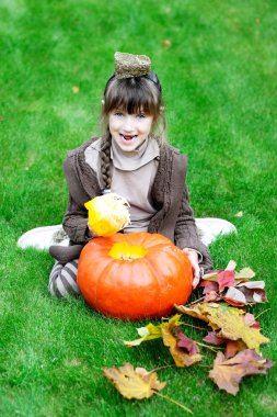 küçük bir kız ile büyük kabak çim üzerinde yalan