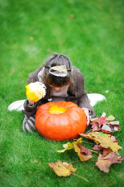 Bambina guardando dentro grande zucca — Foto Stock