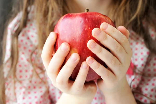 Red ripe apple in child — Stock Photo, Image