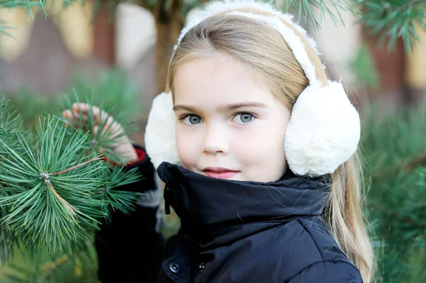 Portrait of little girl in white earmuffs — Stock Photo, Image