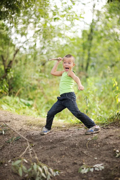Chlapec hraje starobylé lovec s dřevěným kopím — Stock fotografie