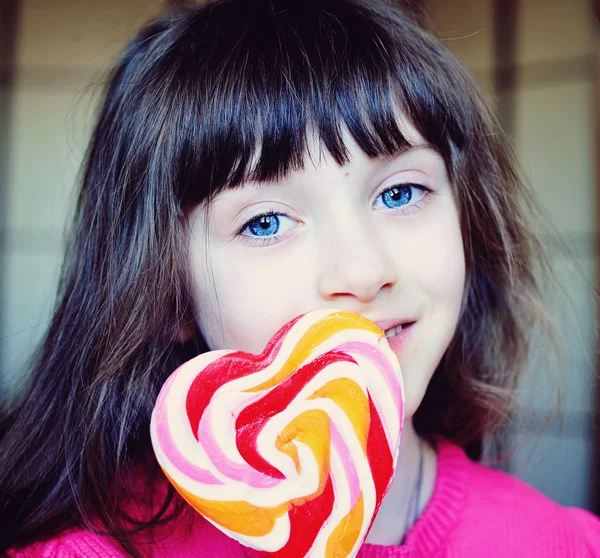 Petite fille avec des bonbons en forme de coeur — Photo