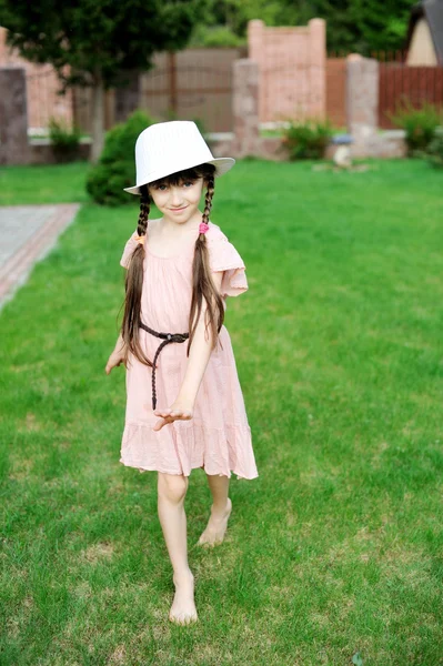 Εκπληκτικό μικρό κορίτσι στο ροζ φόρεμα και το λευκό καπέλο — Φωτογραφία Αρχείου